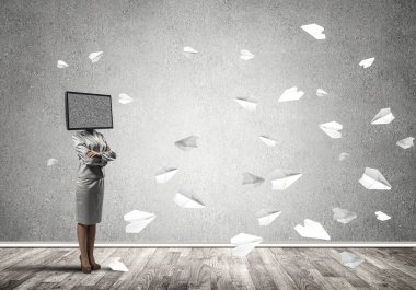 Kağıt uçaklar ile gri karanlık duvar boş oda içinde arka planda uçan arasında duran bir iş kadını kafasına silah tutmak yerine TV elbiseli geçti.