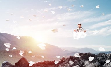 Genç küçük çocuk gözleri koruma kapalı ve seyir ile güzel ve nefes kesici manzara arka plan üzerinde havada bulut üzerinde meditasyon sırasında konsantre.