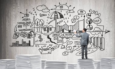 El ile arka planda iş-analitik bilgi belgeleri yığını üzerinde ayakta hoparlör ile iş adamı. Karışık teknik.