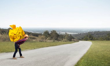 Sırtında kağıt top taşıyan inşaatçı.