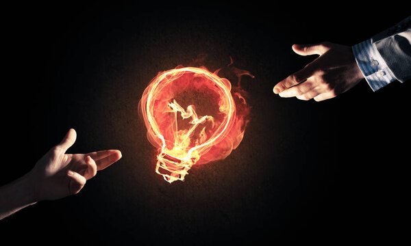 Close of businessman hand showing at glowing fire light bulb icon