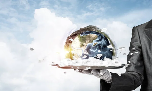 Cropped image of waitress's hand in white glove presenting Earth globe on metal tray with cloudy skyscape on background. 3D rendering. Elements of this image are furnished by NASA.