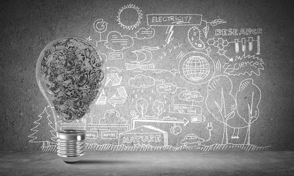 Lightbulb with multiple gears inside placed against eco-analytical information sketched on grey wall. 3D rendering.