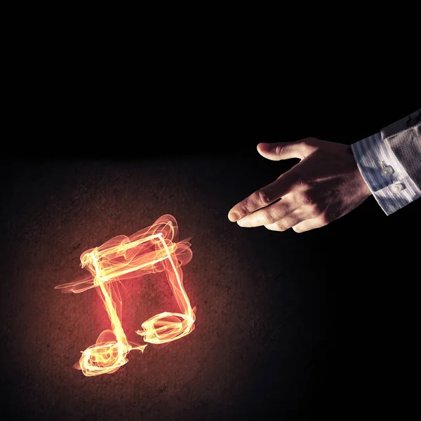 Close up of person hand and fire music symbol on dark background