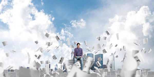 Ein Junger Mann Lässiger Kleidung Sitzt Inmitten Fliegender Papierdokumente Mit — Stockfoto