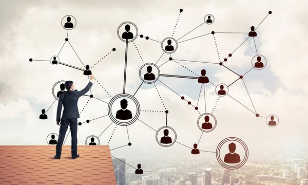 Delikanlı çatıda dikiliyor ve bağlantı hatları çiziyor. Karışık ortam