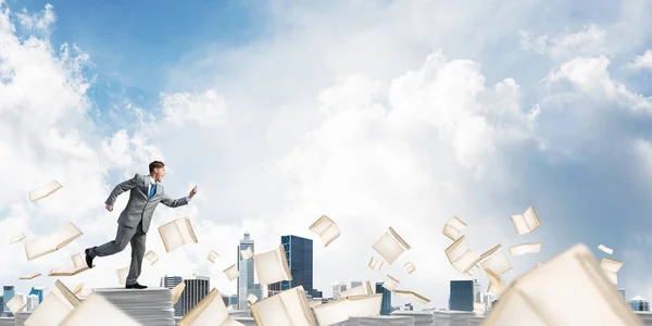 Бізнесмен Костюмі Працює Телефоном Руці Серед Літаючих Книг Хмарним Небом — стокове фото