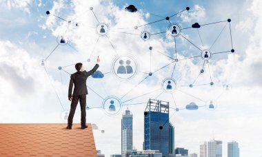 Delikanlı çatıda dikiliyor ve bağlantı hatları çiziyor. Karışık ortam