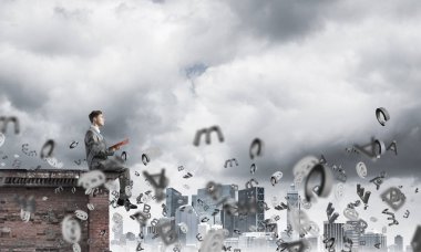 Elinde kırmızı kitap ile üst yapı üzerinde oturan genç işadamı