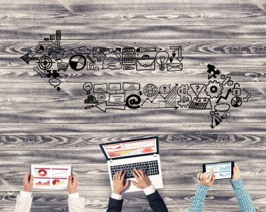 Ellerinde cihazlar bulunan bir grup insan, iletişim ve ağın sembolü olarak birlikte çalışıyor.