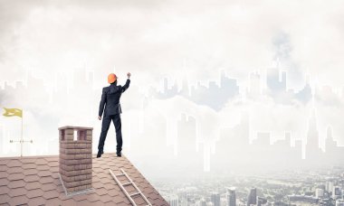 Mühendis, evinin çatısına geri döndü ve şehri çiziyor. Karışık ortam