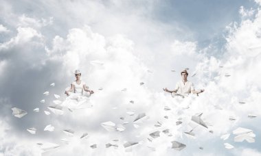 Genç çift gözleri koruma kapalı ve seyir kağıt uçaklar hava bulutlu gökyüzü ile arka plan üzerinde uçan arasında meditasyon sırasında konsantre.