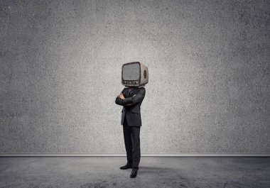 Arka plan üzerinde duran gri Duvar ile boş oda içinde iş başına silah tutmak yerine eski bir Tv ile takım elbiseli adamı geçti.