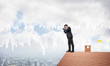 Genç işadamı dürbünüyle şehir manzarasını izliyor. Karışık ortam