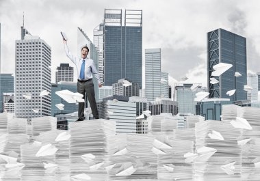 Kağıt uçan arasında duran el kitabı ile uydurarak işadamı ile cityscape arka plan üzerinde uçak. Karışık teknik.