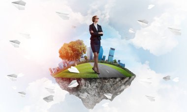 Mavi gök yeşil yüzen ada üzerinde duran zarif emin iş kadını