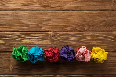 Yeni fikirlerin arama aracı olarak ahşap tablo satırında birden çok renkli crampled kağıt topu kümesi yerleştirilir.