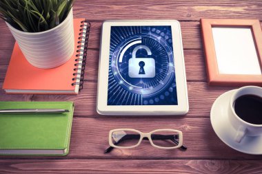 Ofis eşyalarıyla iş yeri ve ekranda asma kilit simgeleri olan tablet