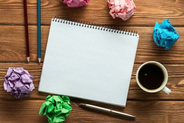 Not defteri, kurşun kalem, buruşuk Kağıt topları ve kahve ile modern yaratıcı çalışma alanı'nın üst görünümden ahşap tablo.