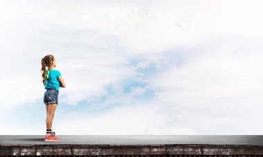 Sevimli kız elleri ile çatı yapı üzerinde ayakta göğüs üzerinde çarpı işareti