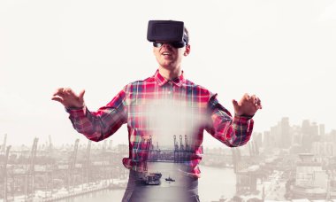 Sanal gerçeklik kulaklığı olan genç bir adam ya da şehrin arka planında 3 boyutlu gözlüklü.