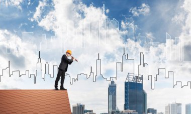 Takım elbiseli genç işadamı ve çatıda kask var. Karışık ortam