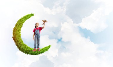 Yeşil Ay 'da durup uçak oyuncağıyla oynayan tatlı kız.