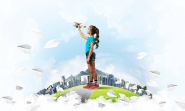 Şehrin yüzen adasında eski model uçaklarla oynayan tatlı bir kız.