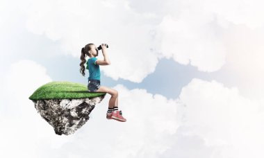 Gökyüzünde yüzen bir adada oturan tatlı, gülümseyen bir kız.