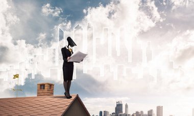 Evin çatısında baş durmak yerine kamerayla zum yapan yüzsüz iş kadını.