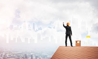 Mühendis, evinin çatısına geri döndü ve şehri çiziyor. Karışık ortam