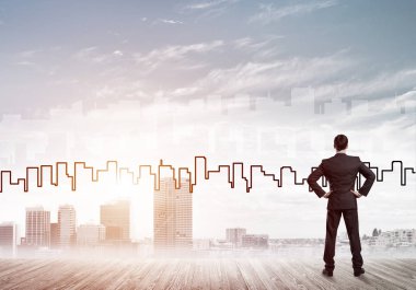 İşadamı arkasını dönüp modern iş merkezinin siluetine bakıyor.