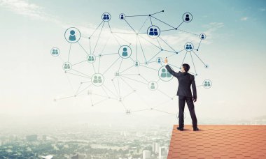 Delikanlı çatıda dikiliyor ve bağlantı hatları çiziyor. Karışık ortam