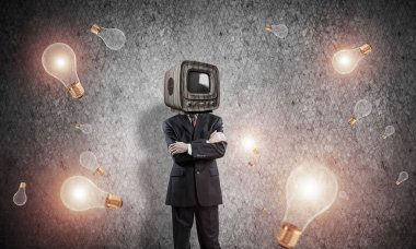 İşadamı kıyafetli kafa kol kesimine uçan arasında duran geçti tutmak yerine eski Tv ve arka plan üzerinde koyu gri Duvar ile.