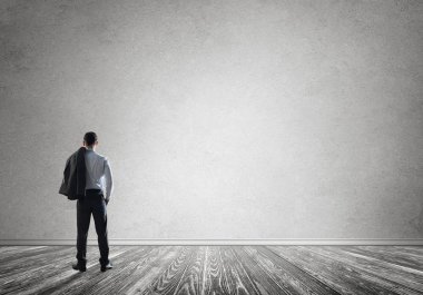 Boş beton odada kendine güvenen zarif iş adamının arka planı