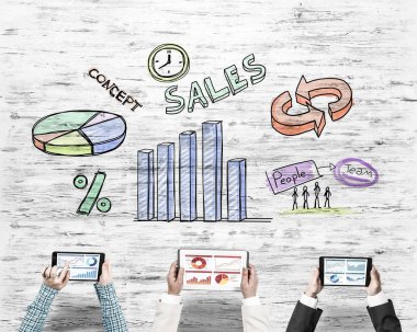 Ellerinde cihazlar bulunan üç kişilik bir grup iletişim ve ağ oluşturma sembolü olarak birlikte çalışıyor.