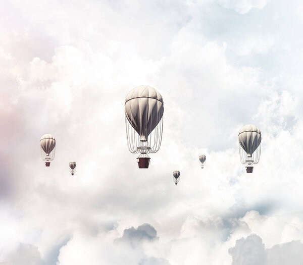 Colorful aerostats flying over the blue cloudy sky. 3D rendering.