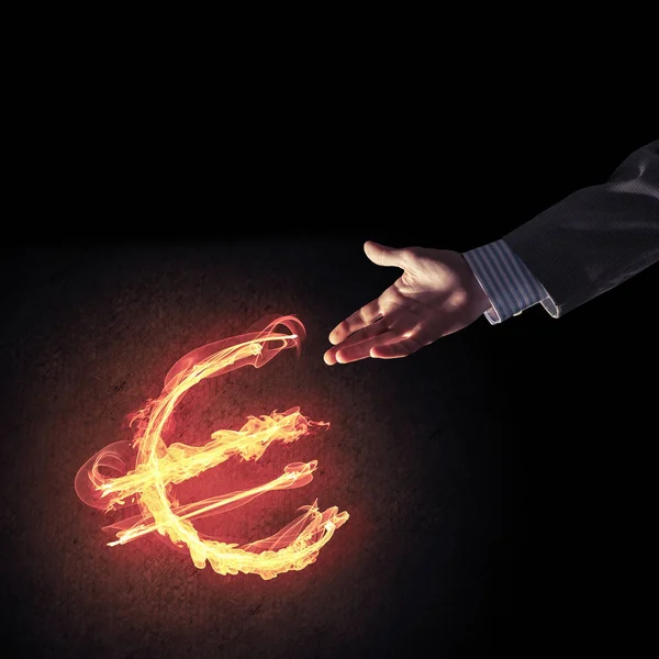 ユーロ記号を輝く火を指してビジネスマンの手を閉じる — ストック写真
