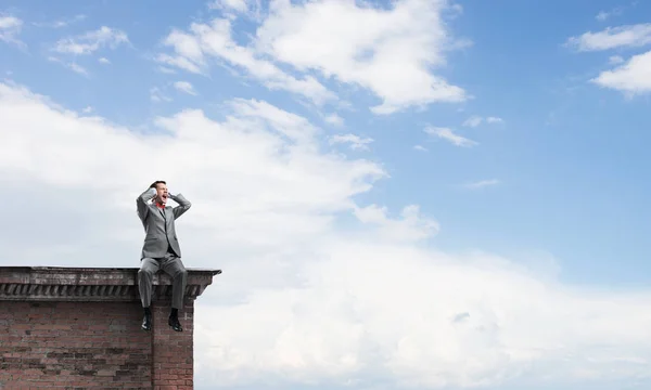 Frustrierter Geschäftsmann Sitzt Auf Hausdach Und Schließt Die Ohren Mit — Stockfoto