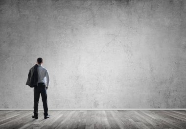 Boş beton odada kendine güvenen zarif iş adamının arka planı