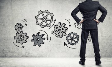 İş adamının çizilmiş dişli mekanizmasıyla duvara baktığı arka plan