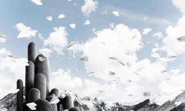 Açık havada, arka planda güzel manzarası olan uçan kağıt uçaklar arasında yer alan yüksek ve büyük taş sütunların resmi. Duvar kağıdı, telif alanı olan arkaplan.