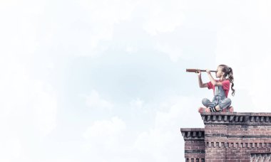 Evin çatısında oturan ve dürbüne bakan tatlı bir kız.