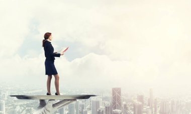 Garsonun eli tepside kitap okuyan kadını sunar.