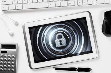 Ofis eşyalarıyla iş yeri ve ekranda asma kilit simgesi olan tablet