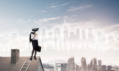 Evin çatısında baş durmak yerine kamerayla zum yapan yüzsüz iş kadını.