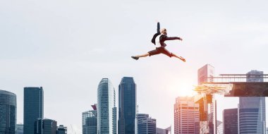 İş kadını zorlukların üstesinden sembolü olarak büyük boşluğu beton köprü üstünden atlayarak. Cityscape zemin üzerine güneş ışığı ile. 3D render.