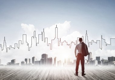 İşadamı arkasını dönüp modern iş merkezinin siluetine bakıyor.