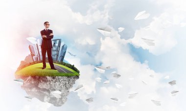 Mavi gök yeşil yüzen ada üzerinde duran zarif emin iş adamı