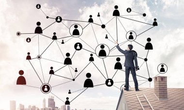 Delikanlı çatıda dikiliyor ve bağlantı hatları çiziyor. Karışık ortam